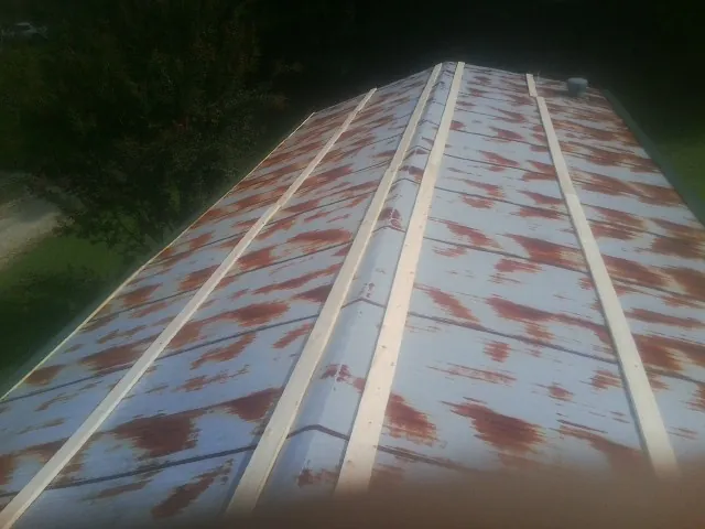 Rusted metal roof panels with new wood purlins before replacement — Storm Damage Roof Repair in Kure Beach by Roofing Brothers