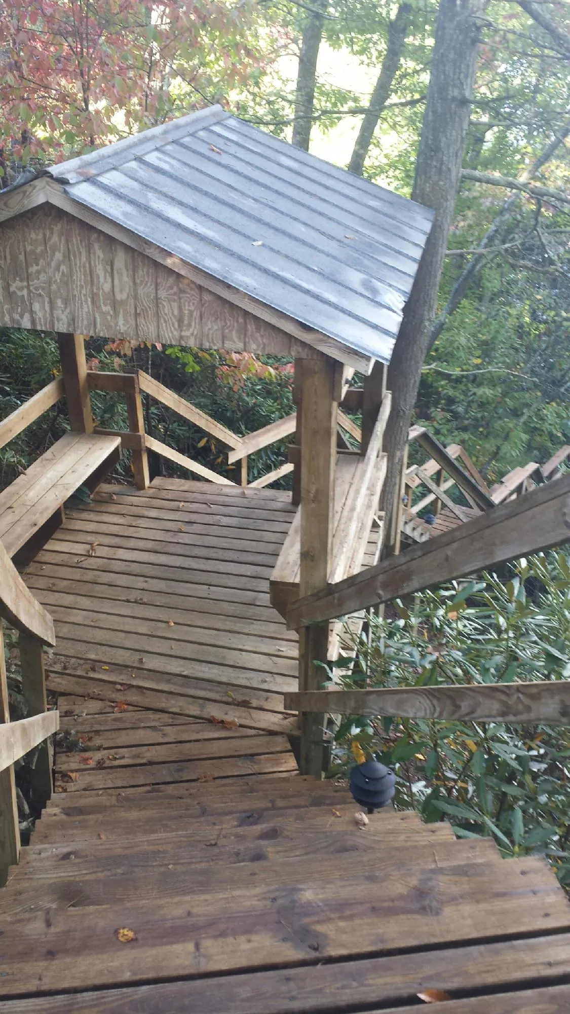Metal roofed shelter over wooden steps on a wooded walkway — Skylight Repair & Installation work by our crew in Kure Beach