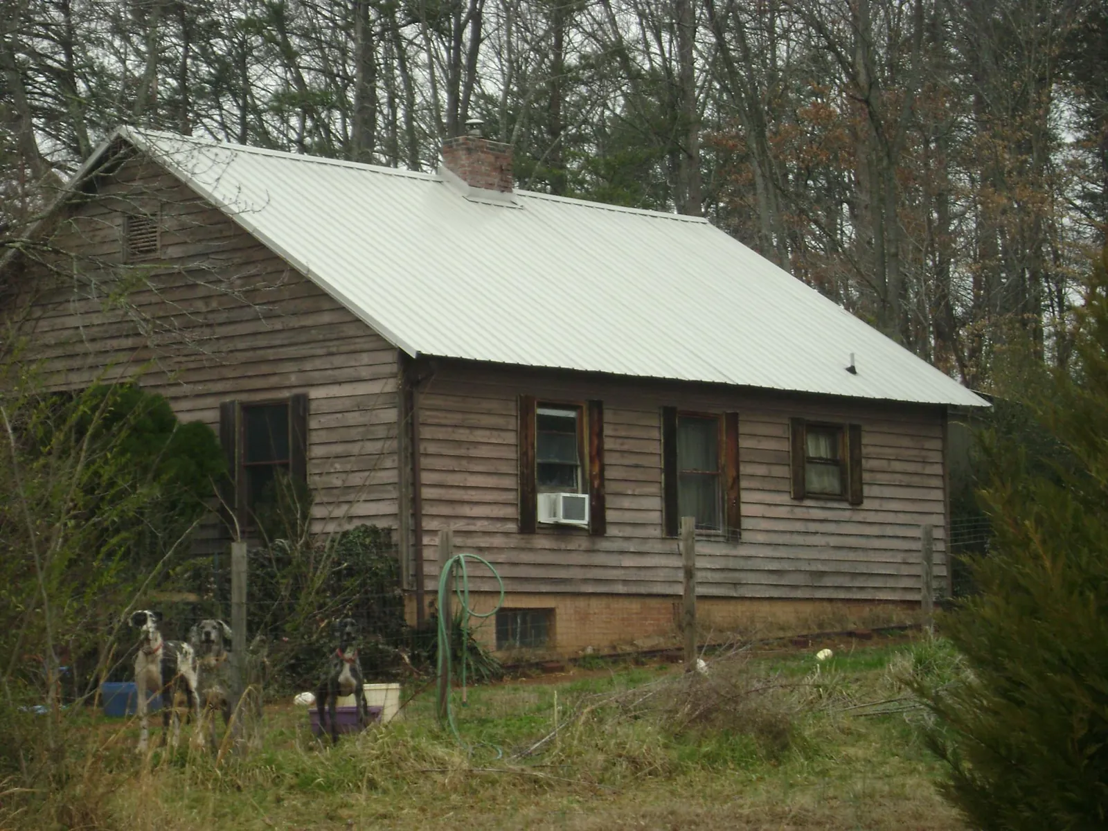 White metal roof on an old wood sided farmhouse, from a Metal Roof Installation job in Kure Beach